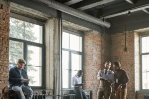 Menschen arbeiten und sprechen in einem industriellen Backsteinbüro