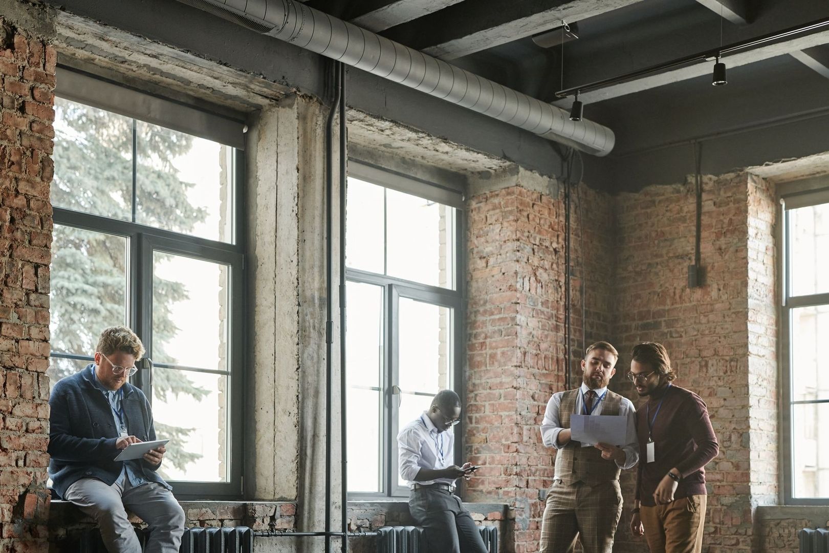 Menschen arbeiten und sprechen in einem industriellen Backsteinbüro