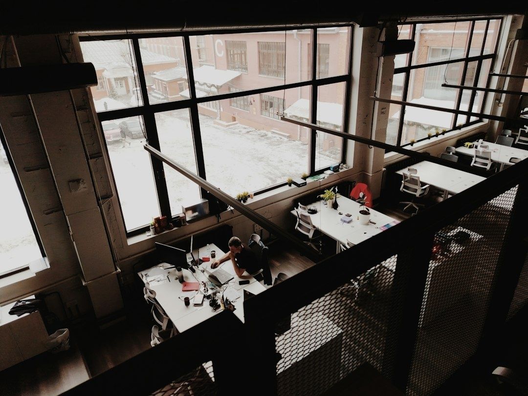 Industrielles Co-Working-Büro mit Arbeitsplätzen an großen Fenstern